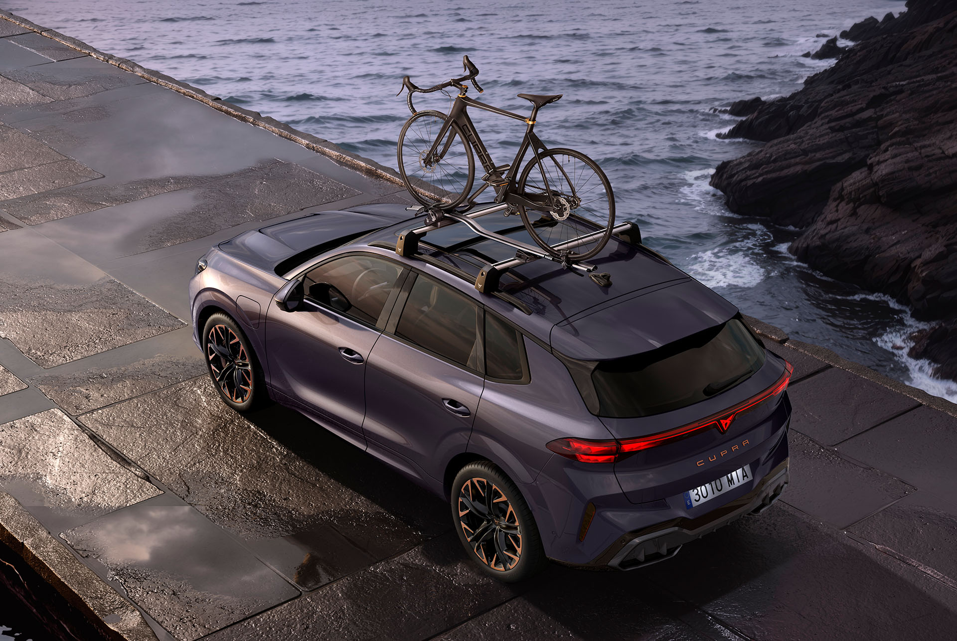 CUPRA Terramar with bike rack carrying two bikes. The SUV is parked on a coastal road, showcasing the ease of setting up the rack and its secure anti-theft system, ready for an adventure. CUPRA Terramar with bike rack carrying two bikes. The SUV is parked on a coastal road, showcasing the ease of setting up the rack and its secure anti-theft system, ready for an adventure.