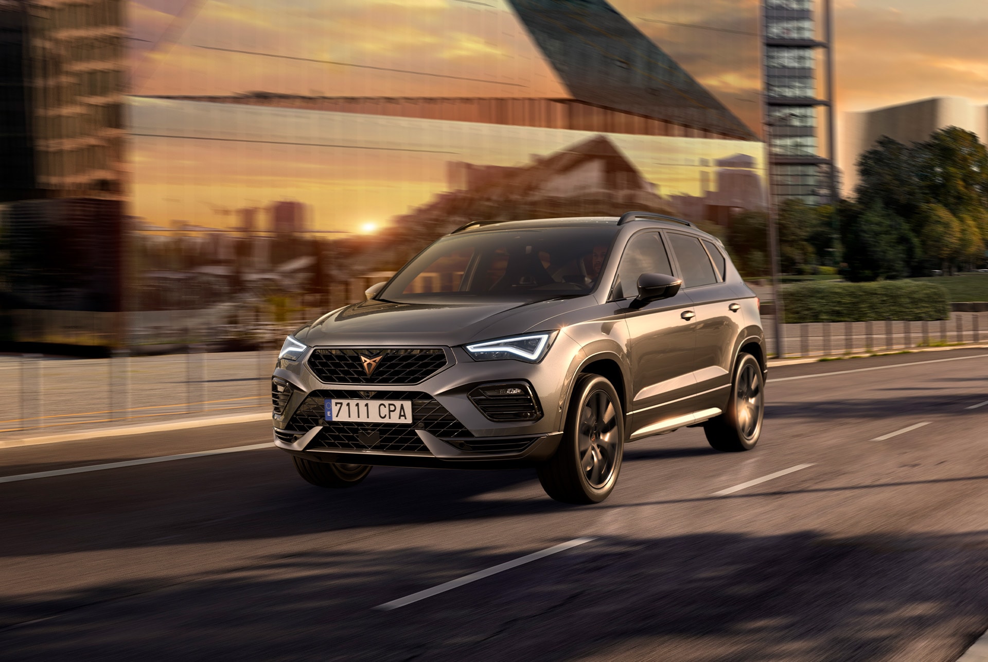 A CUPRA Leon Sportstourer shown from an elevated angle, with a person draped in dark, flowing fabric that creates a dynamic, red-lit trail beside the car.